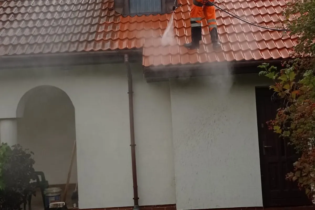 Pracownik BruClean Service podczas mycia ciśnieniowego dachu w Krakowie